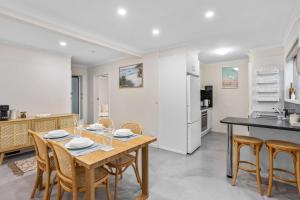 eine Küche und ein Esszimmer mit einem Tisch und Stühlen in der Unterkunft Holiday on Hedges - Simple Beachside Comforts in Gold Coast
