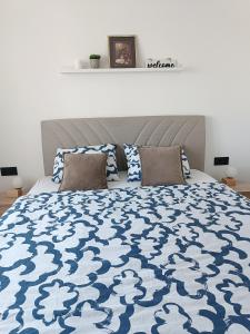 トゥズラにあるZen Apartment Tuzlaのベッドルーム1室(青と白の掛け布団付きのベッド1台付)