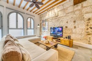 a living room with a large couch and a tv at Mercat 16 in Sa Pobla