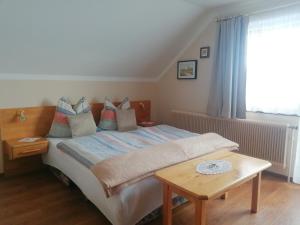 1 dormitorio con 1 cama con mesa y ventana en Fanningerwirt en Mariapfarr
