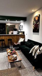 een woonkamer met een zwarte bank en een tafel bij Loft Rezé in Rezé
