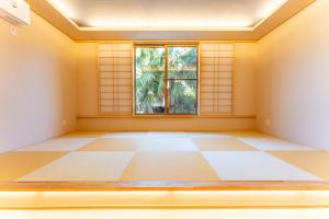 an empty room with a window and a tiled floor at HAKO REIRO 箱・玲瓏 in Hakone