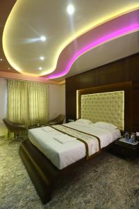 um quarto com uma cama grande e iluminação roxa em Hotel White Rock em Bangalore