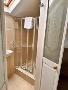 a shower with a glass door in a bathroom at Charming 2 Bedroom Cottage in Staines Upon Thames in Staines upon Thames