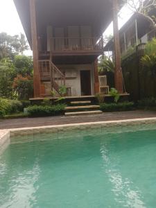 a house with a swimming pool in front of it at Ubud Sawah Scenery Villa and Homestay in Tegalalang