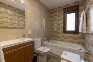 a bathroom with a tub and a toilet and a sink at BiBo Suites Sierra Nevada in Sierra Nevada