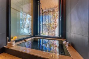 bañera en una habitación con ventana grande en HAKO REIRO 箱・玲瓏, en Hakone
