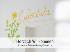 ein Schild für ein Bad mit einer Blume an der Wand in der Unterkunft Bio Ferienhof Wichtelweide - Fewo Calendula in Fehmarn + 50 Fotos