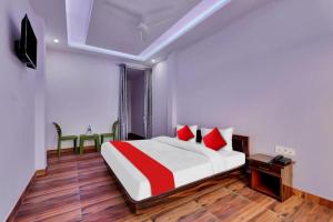 um quarto com uma cama com almofadas vermelhas e brancas em Bala Shankar Resort Kujarwal Group em Haldwani-cum-Kathgodam