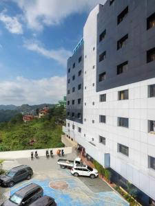 a building with cars parked in a parking lot at Misty Hills in Baguio