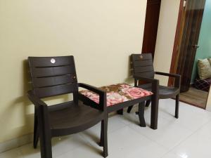 two chairs sitting next to each other in a room at Excelol Home Stay in Thane