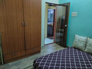 a bedroom with a bed and a closet and a mirror at Excelol Home Stay in Thane