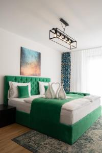 a green bed with two white pillows on it at City Stay Vienna – Lugeck in Vienna