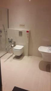 a bathroom with a toilet and a sink at High House in Sharurah