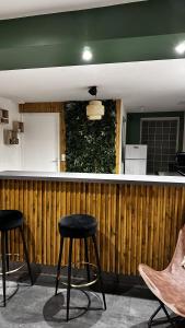 a bar with two stools in front of a wooden wall at Loft Rezé in Rezé