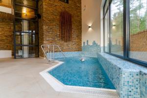 a pool in a house with a brick wall at Spa & Wellness Hotel Fitak**** in Liptovský Ján