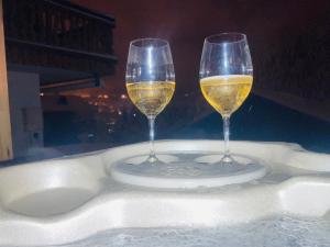 twee glazen wijn op een bord op een tafel bij Chalet individuel 8 pers à Chatel Porte du soleil avec Jacuzzi exterieur in Châtel