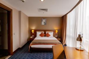 um quarto de hotel com uma cama e uma secretária em Parkside Hotel & Apartments em Baku