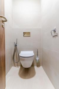 a white bathroom with a toilet and a shower at Spa & Wellness Hotel Fitak**** in Liptovský Ján