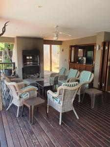 porche con sillas de mimbre y chimenea en Elements Golf Reserve House 303, en Moheme