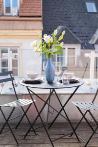 un tavolo con un vaso blu con dei fiori sopra di City Stay Vienna – Lugeck a Vienna