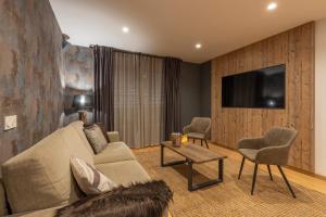 a living room with a couch and a tv at BiBo Suites Sierra Nevada in Sierra Nevada