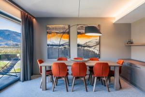 une salle à manger avec une table blanche et des chaises orange dans l'établissement The Lodge Sporthotel - Golfclub Eppan, à Appiano sulla Strada del Vino