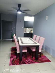une table à manger avec des chaises roses et un ventilateur de plafond dans l'établissement Jannah Guest House Putrajaya, à Putrajaya
