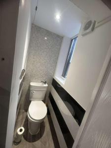 a small bathroom with a toilet and a window at M&B Accommodation in Lincoln