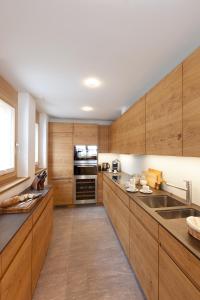 a kitchen with wooden cabinets and stainless steel appliances at Chalet Binna in Zermatt