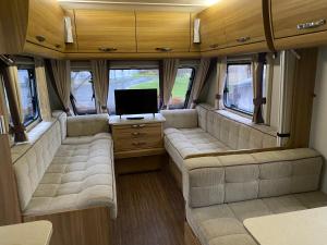 een woonkamer met banken en een tv in een camper bij RostrevorValley Caravan Experience Private HotTub in Rostrevor