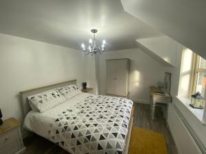 una camera con letto bianco e lampadario pendente di Rostrevor Valley Resort- Full House a Newry