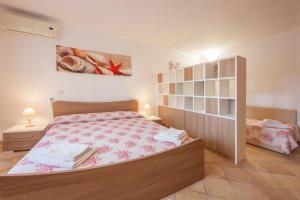 - une chambre avec un lit et une étagère dans l'établissement Apartment I Nidi dei Cormorani, à Costa Rei