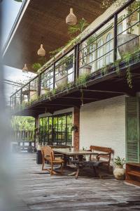 eine Terrasse mit einem Tisch und Bänken sowie einem Balkon in der Unterkunft White Penny Hostel in Seminyak