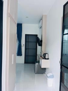 a white kitchen with a blue door and a table at White Seaview Residence in Klong Muang Beach