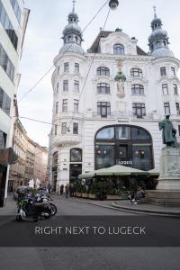 un grande edificio bianco con una moto davanti di City Stay Vienna – Lugeck a Vienna