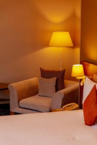 Parkside Hotel & Apartments في باكو: غرفة معيشة مع أريكة ومصباح