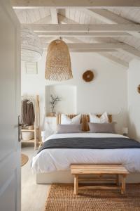 ein Schlafzimmer mit einem großen Bett und einer Holzbank in der Unterkunft Villa Vin - Pool, ruhig, strandnah, Klimaanlage, Außenküche, Meeresnähe, Gästebetreuer in Babići + 35 Fotos