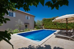 eine Villa mit Swimmingpool und Sonnenschirm in der Unterkunft Villa Vin - Pool, ruhig, strandnah, Klimaanlage, Außenküche, Meeresnähe, Gästebetreuer in Babići
