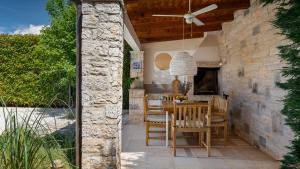 ein Esszimmer mit einem Tisch und Stühlen auf einer Terrasse in der Unterkunft Villa Vin - Pool, ruhig, strandnah, Klimaanlage, Außenküche, Meeresnähe, Gästebetreuer in Babići