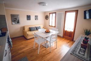 sala de estar con mesa y sofá en Appartamento - Borgo55 - Centro Paese, en Bosco Chiesanuova