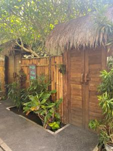Cabaña de madera con techo de paja en un jardín en Jepun Villas 11 - One Bedroom with kitchen, en Uluwatu 6 fotos más