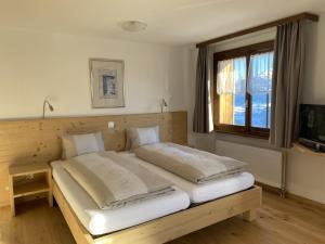 Postel nebo postele na pokoji v ubytování Hotel Garni Postigliun Andiast