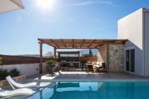 een patio met een zwembad en een houten pergola bij Solis Villa, with Heated Pool & 5 minutes to Beach, By ThinkVilla in Kavros