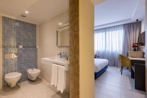 a bathroom with a sink and a toilet and a bed at Kenzi Solazur in Tangier