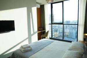 a hotel room with a bed and a large window at Season Suite Apart-Hotel in Batumi