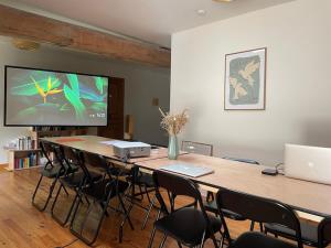 a conference room with a table with chairs and a television at L'ancien Relais de Poste*** in Saint-Dier-dʼAuvergne