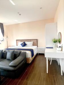 um quarto com uma cama e um sofá em Kim Boutique Hotel em Duong Dong