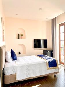 a bedroom with a large bed and a flat screen tv at Kim Boutique Hotel in Phu Quoc