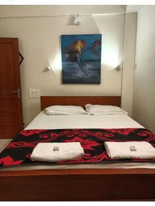 a bedroom with a bed with two towels on it at Aambal Residency in Cochin